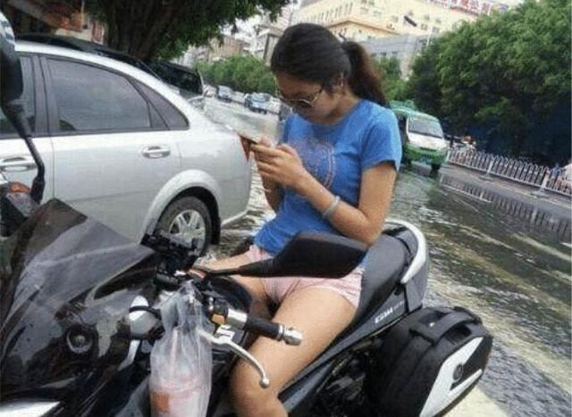 妹子骑车的时候注意点，别光顾着玩手机了，尤其是在下雨天。哈哈哈...