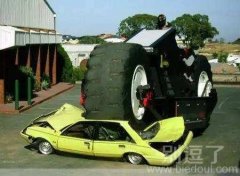 在大轮子下的小轿车。