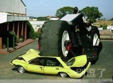 在大轮子下的小轿车。