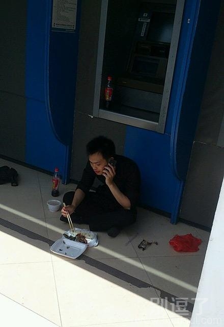 在自助机旁吃饭的哥们。