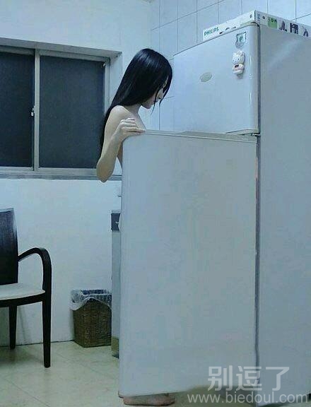 站在冰箱旁的美女。