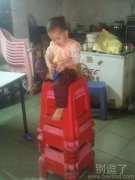 坐在小凳上的小孩。