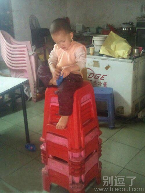 坐在小凳上的小孩。 坐在小凳上的小孩。